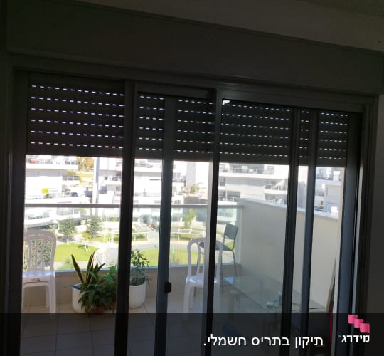 תריסים סגורים למחצה על חלון זכוכית במרפסת